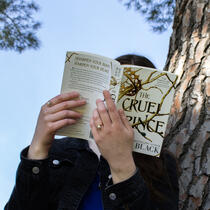 Girl holding book over her face